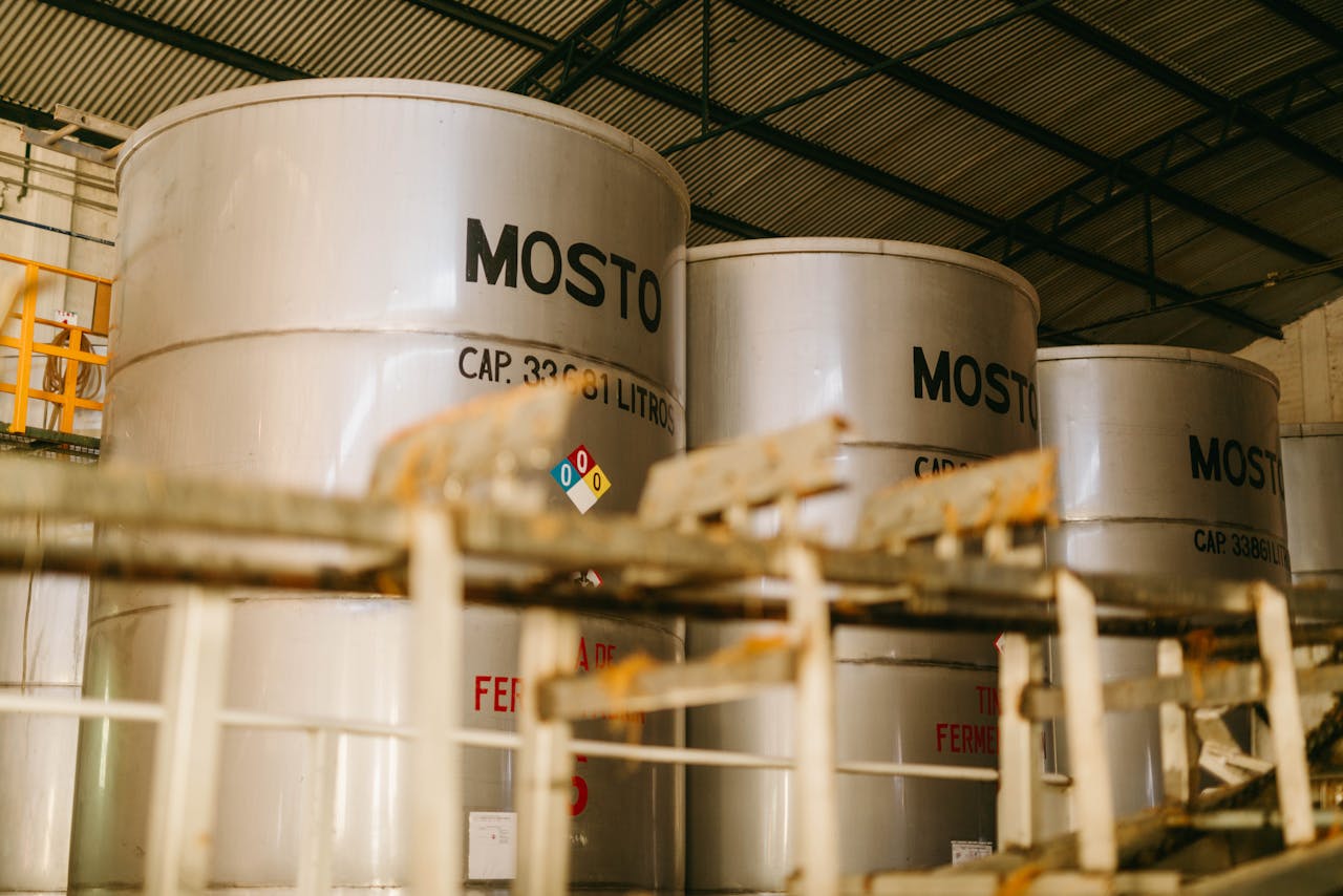 services-02 Interior view of an industrial tequila distillery with large metal containers labeled 'Mosto'.