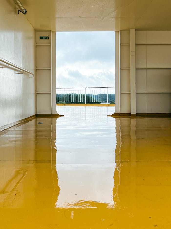 View from a ferry deck in Stockholm with wet yellow floor reflecting light.