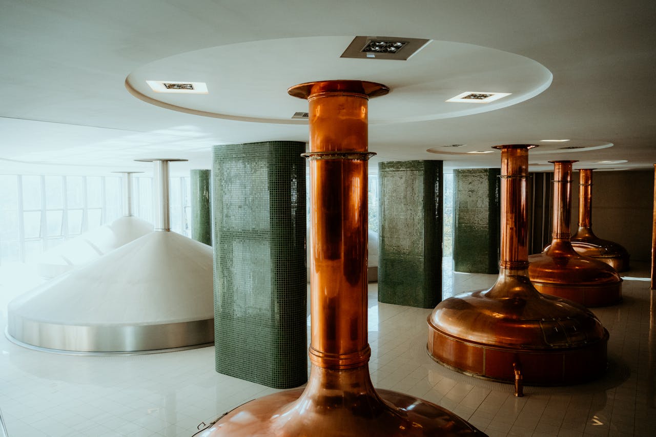 Interior view of a brewery in Pilsen, showcasing copper tanks and modern design.