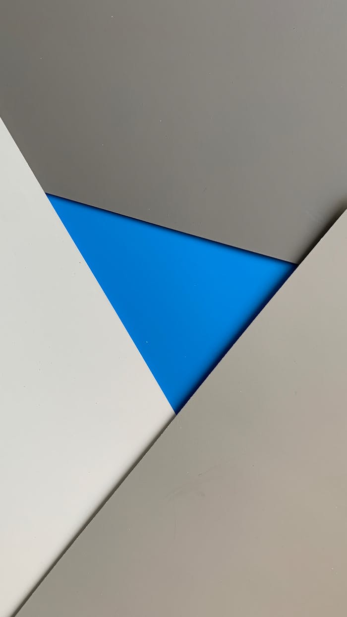 why-choose-us A modern geometric abstract design featuring a striking blue triangle amid neutral tones, ideal for creative projects.